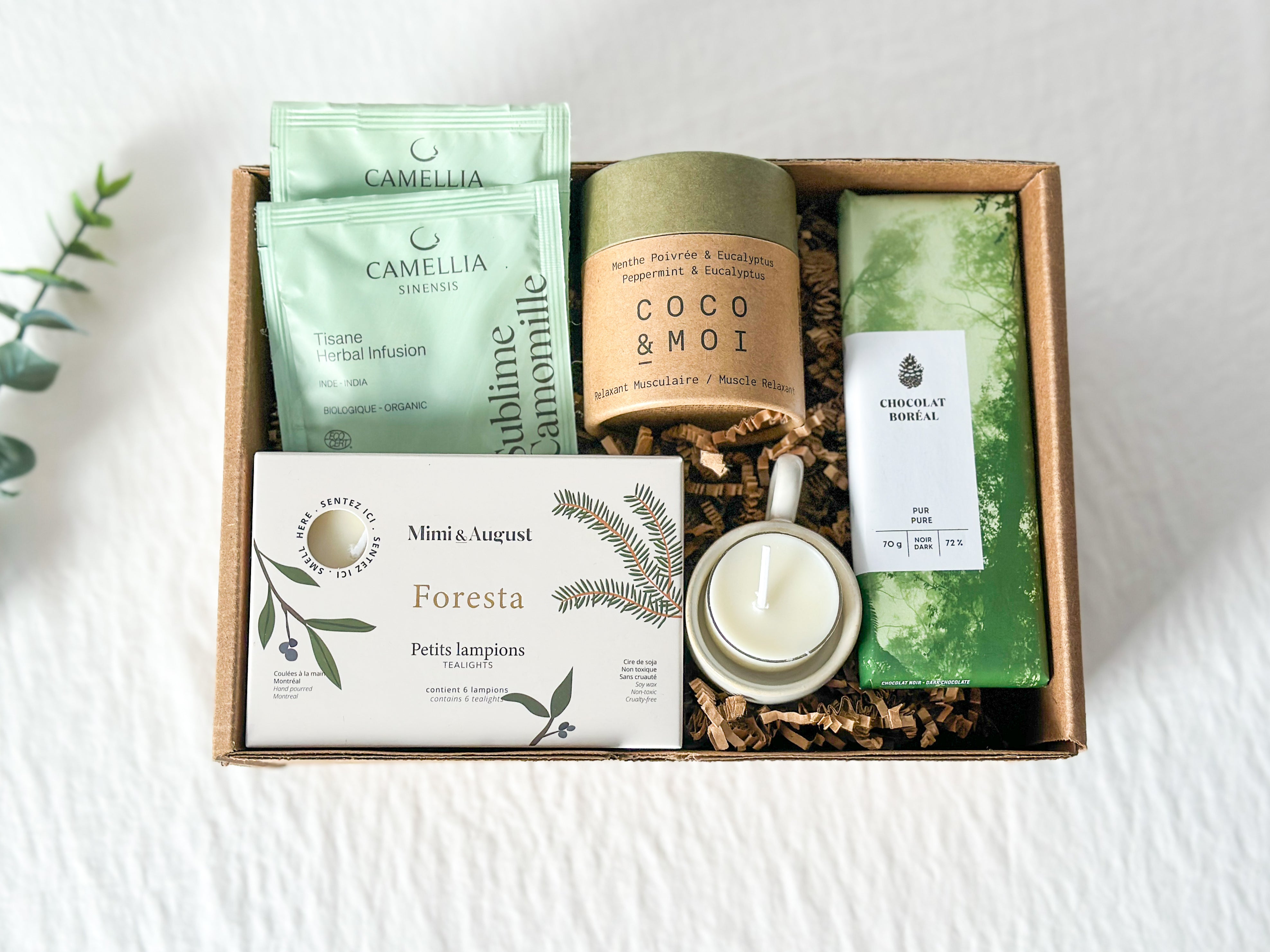 Boîte cadeau « Dans nos pensées » composée de lampions Mimi & August, bougeoir en bois Kotmo, chocolat noir 72 % Chocolat Boréal, tisane biologique Camellia Sinensis et bombe de bain Coco & Moi, une attention réconfortante pour offrir soutien et douceur.